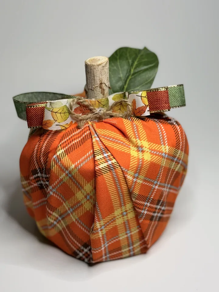 Tall orange plaid fabric pumpkin with a natural wood stem, ivy leaves, jute, and narrow autumn leaf ribbon.
